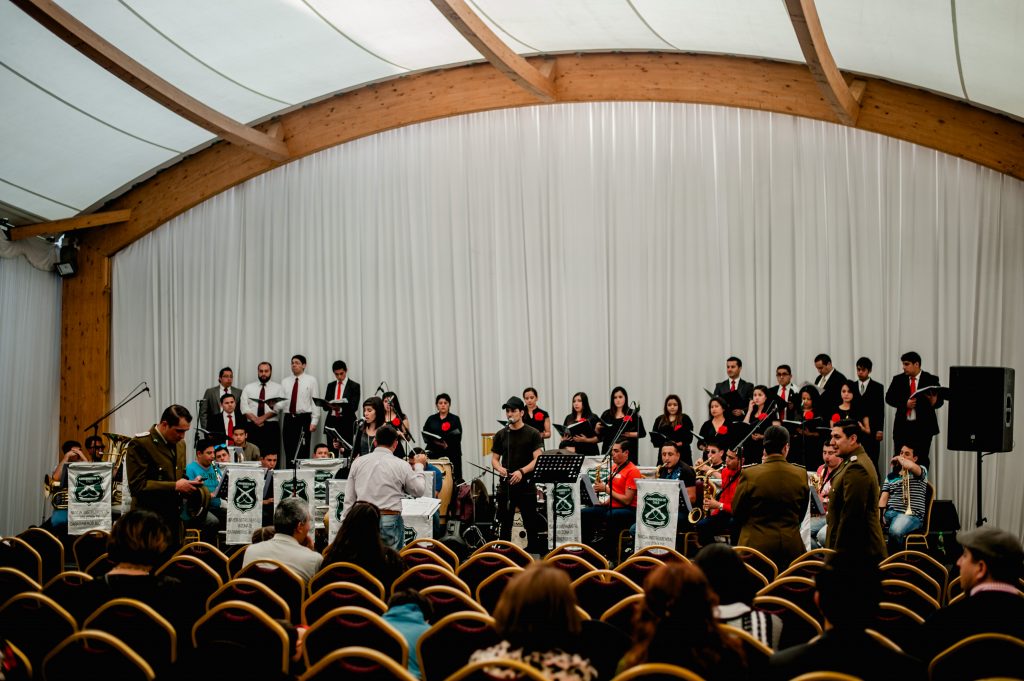 Luis Layseca junto a la Orquesta de Carabinero y al Coro de la Iglesia SUD de la Región Concepción durante el ensayo general. | Niko Serey, El Faro Mormón.